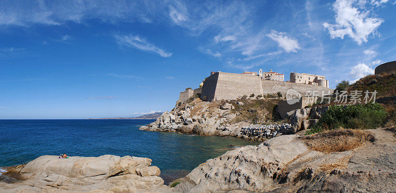 Corsica: the Mediterranean Sea and view of the skyline of the ancient Citadel of Calvi with its ancient walls
